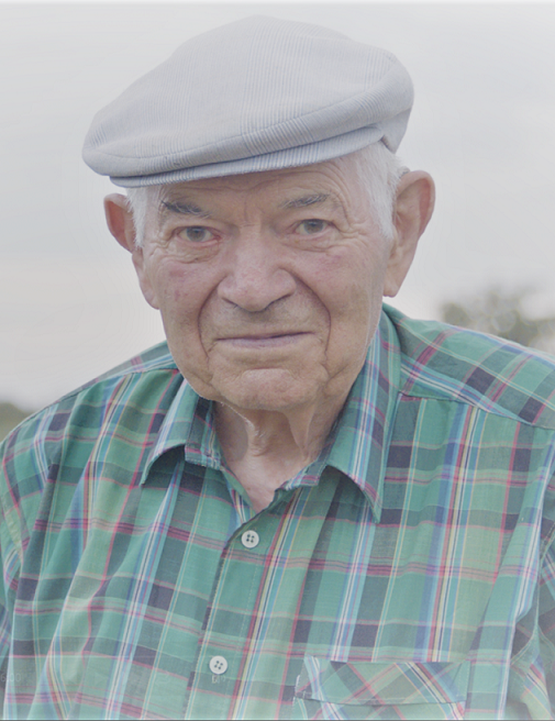 Portrait d'un vieil homme en chemise à verte à carreaux, avec un béret.
L'homme sourit timidement.
image extraite du documentaire Où sont les moutons ?
